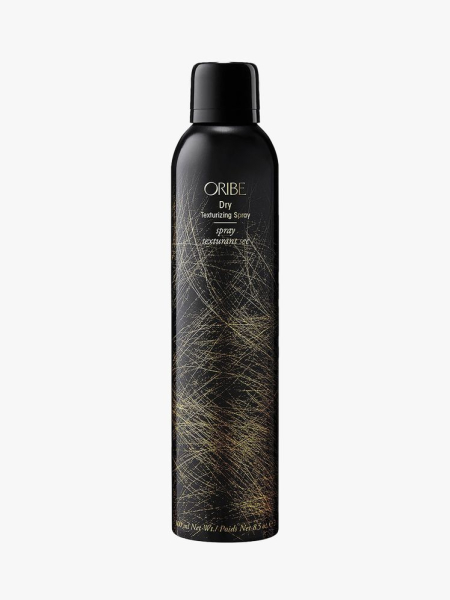 Oribe Dry Texturizing Spray black spray bottle with gold accents on light grey background